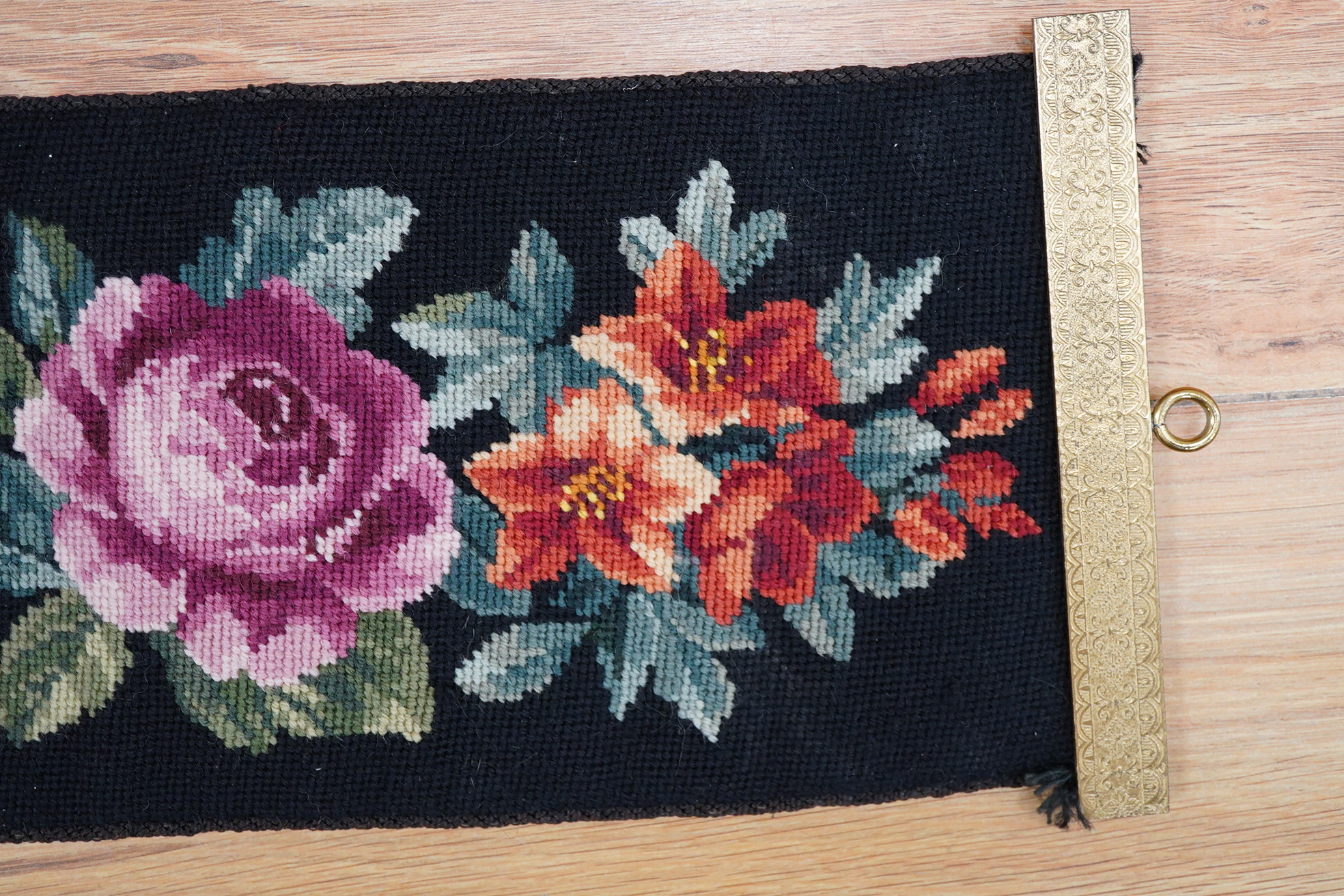 A framed 19th century woolwork embroidery of a bird, a floral wool bell pull with gilt mounts and a large maple frame